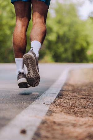 Sport and fitness runner man running on road training for marathon run doing high intensity interval...