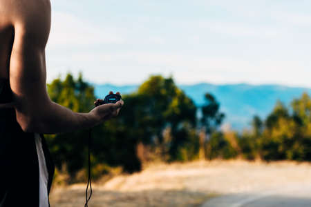Man hand measure time with stopwatch on the mountainの写真素材