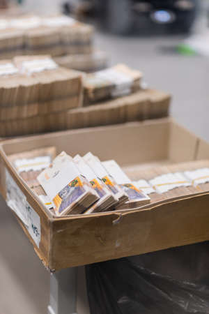 Large sum of money divided with currency straps placed in boxes at the center of cash servicesの写真素材