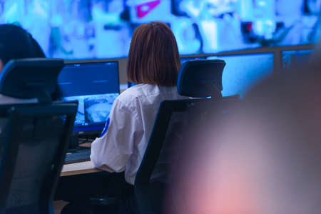 In the System Control Room, Technical Operator Works at His Workstation with Multiple Displays,...