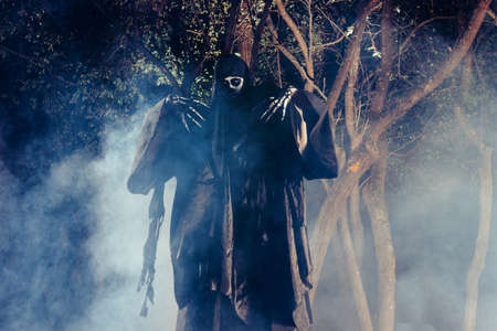 Portrait of the angel of death, grim reaper while standing in a mystical wood at night.の写真素材