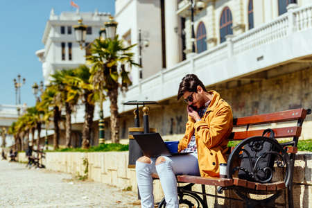 Businessman is having work conversation while sitting outdoorsの写真素材
