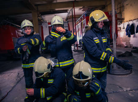 Portrait of group firefighters in front of firetruck inside the fire stationの写真素材