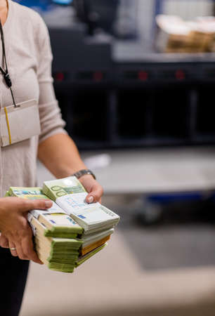 Counting person handling stacks of euro â‚¬ cash sorted with bill bands at the treasury...