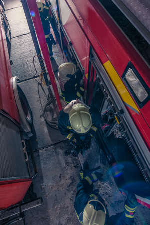 Firemen checking the fire engine inside the fire department from a bird perspective