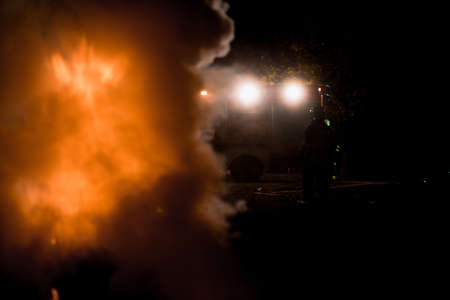 Group of firemen in protective suits putting out a fire