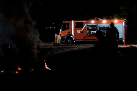 Firemen using fire hose that shoots foam and water during an emergency situationの写真素材