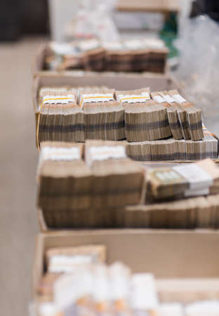 Banknotes strapped with bill bands arranged by number in carton boxes at the treasury departmentの写真素材