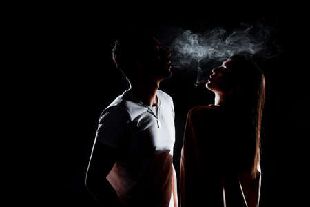 Sexy young couple in trendy stylish clothes smoking cigarettes