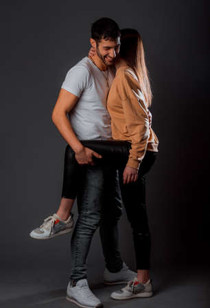 Romantic guy and girl in trendy clothes gently touching and cuddlingの写真素材