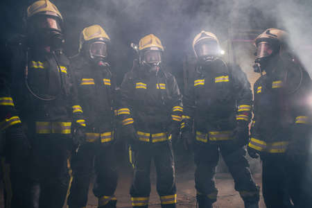 Portrait of group of firefighters in the middle of the smoke of the fire extinguisher