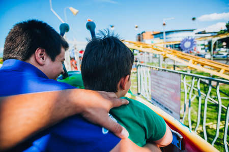 Two young brothers enjoying the rides at the local theme parkの写真素材