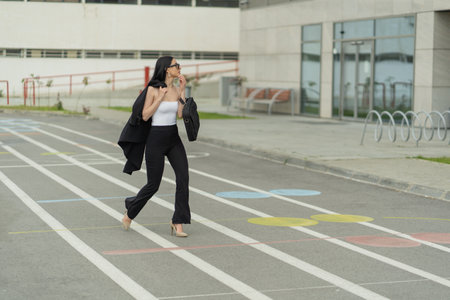 Attractive businesswoman is walking while looking at the companyの写真素材