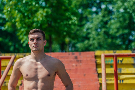 Portrait of a handsome young athlete without t-shirt standing on stairsの写真素材