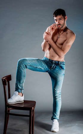 Torso shot of a cool young half naked man wearing modern style jeansの写真素材
