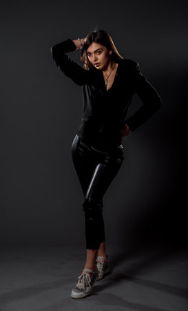 Portrait of an attractive stylish woman posing against dark backgroundの写真素材