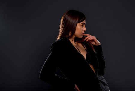 Portrait of a beautiful female model posing in trendy black top and leather pantsの写真素材