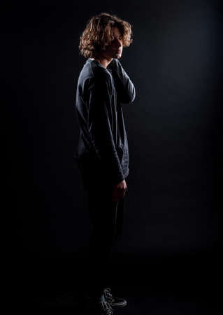 Trendy modern young man dressed in trendy jumper and denim pantsの写真素材