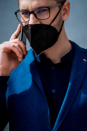 Fashion male businessman with cellphone going in his officeの写真素材