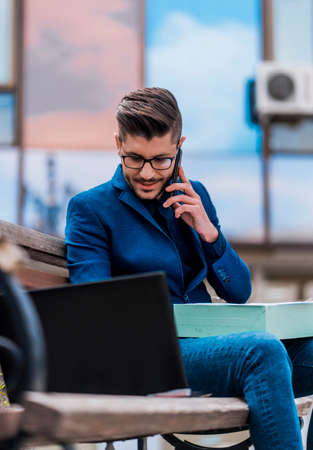 Beautiful businessman is working outside and talking on phoneの写真素材