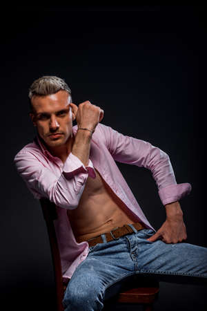 Cheerful young european man posing in modern studioの写真素材