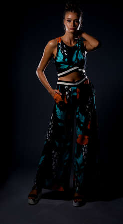 Body shot of a stylish woman posing in black heels and colorful top and pantsの写真素材