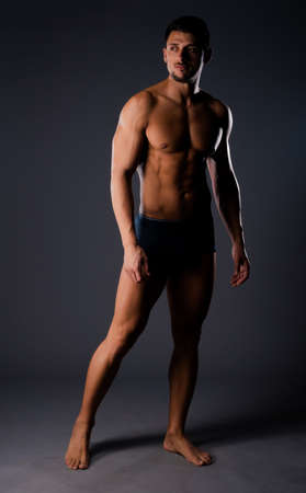 Studio fashion portrait of a half naked man wearing black underwearの写真素材