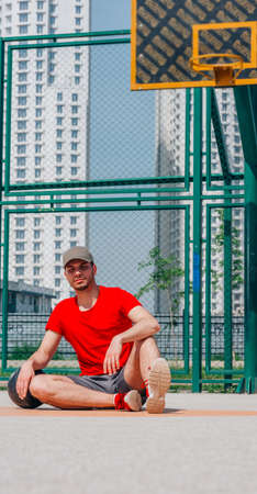 Two basketball players having some rest sitting on the court after an exhausting basketball game.の写真素材