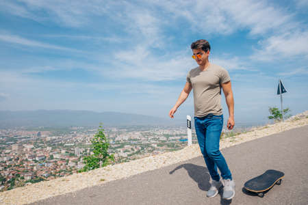 Urban cool longboarder preparing for a downhill ride(slide) doing few stunts and trick on his...