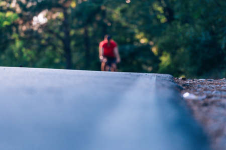 Tall handsome biker rides his bicycle on sunset in a lovely magical forest.の写真素材