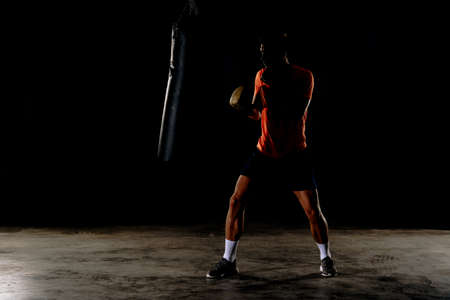 Professional boxer training at gym, practicing kicks and punchesの写真素材