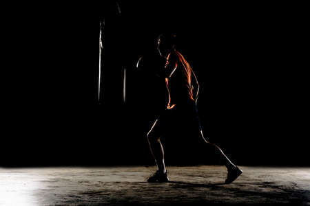 Young man in boxing gloves. Boxing man ready to fight. Boxing, workout, muscle, strength, power - the concept of strength trainingの写真素材