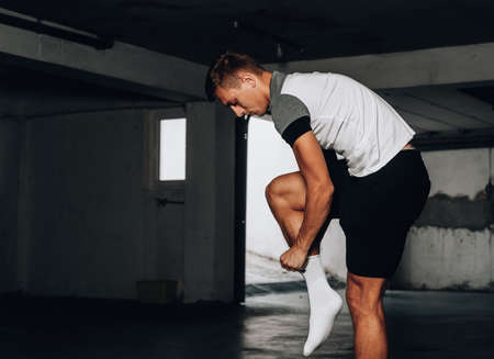 Handsome young boxer prepare for training in undeground garage