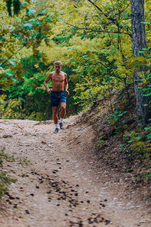Sporty man is runs in the mountains. Functional training of the runnerの写真素材