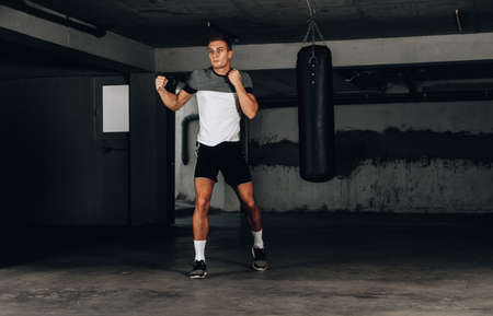 Determined male boxer focused on his training against dark backgroundの写真素材