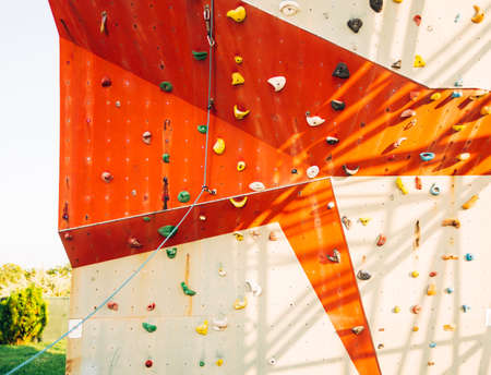 Artificial climbing wall covered with colored holds in an adventure playgroundの写真素材