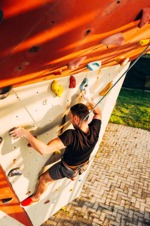Young sporty man is bouldering in a climbing hallの写真素材