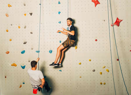 Young climbers prepare to climb on artificial wallの写真素材