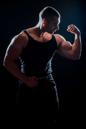 Strong and handsome young man demonstrate his muscular torso and bicepsの写真素材