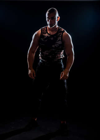 Muscular and fit bodybuilder fitness male model posing over black backgroundの写真素材
