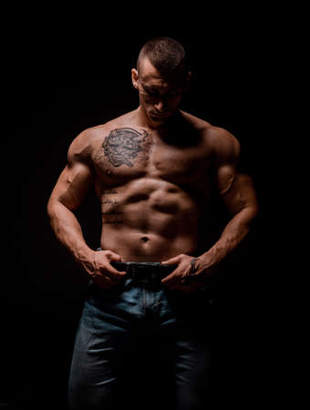 Handsome muscular male model bodybuilder preparing for fitness training.Studio shot on black...