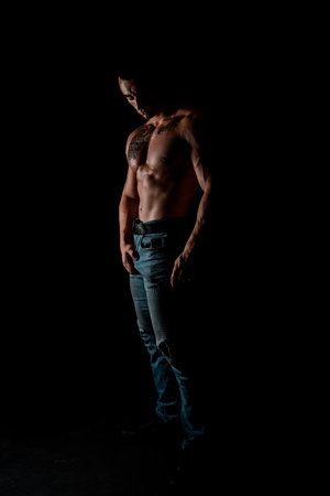 Fit man black background. Fit athlete show muscles. Strong sportsman with fit bodyの写真素材