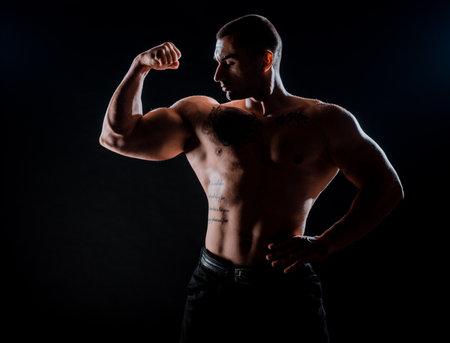 Muscular young fitness sports man workout with dumbbell in fitness gymの写真素材