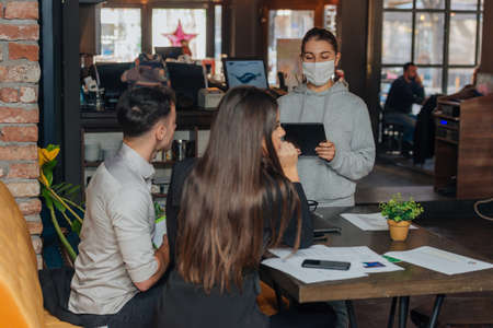 Successful young business people sharing ideas and smiling while working together on a project in a  coffee shop.の写真素材