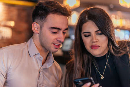 Close up picture of two business colleagues talking in a bar and drinking coffee