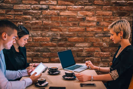 Happy businessman and businesswomen having teamwork meeting for developing new strategies in a cafe.の写真素材