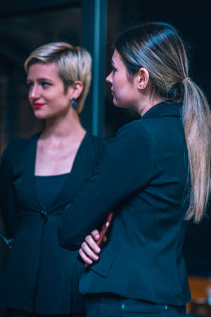 Beautiful businesswomen standing in front of the office listening to their managerの写真素材