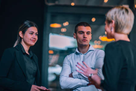 Group of three young entrepreneurs discussing business ideas in front of an office.の写真素材