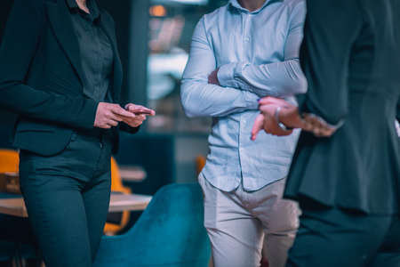 Cropped close-up image of young business partners's hands standing in an office and discussing ideas.の写真素材