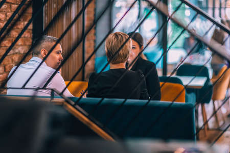 Business meeting inside a cafe with the focus through a fence.の写真素材